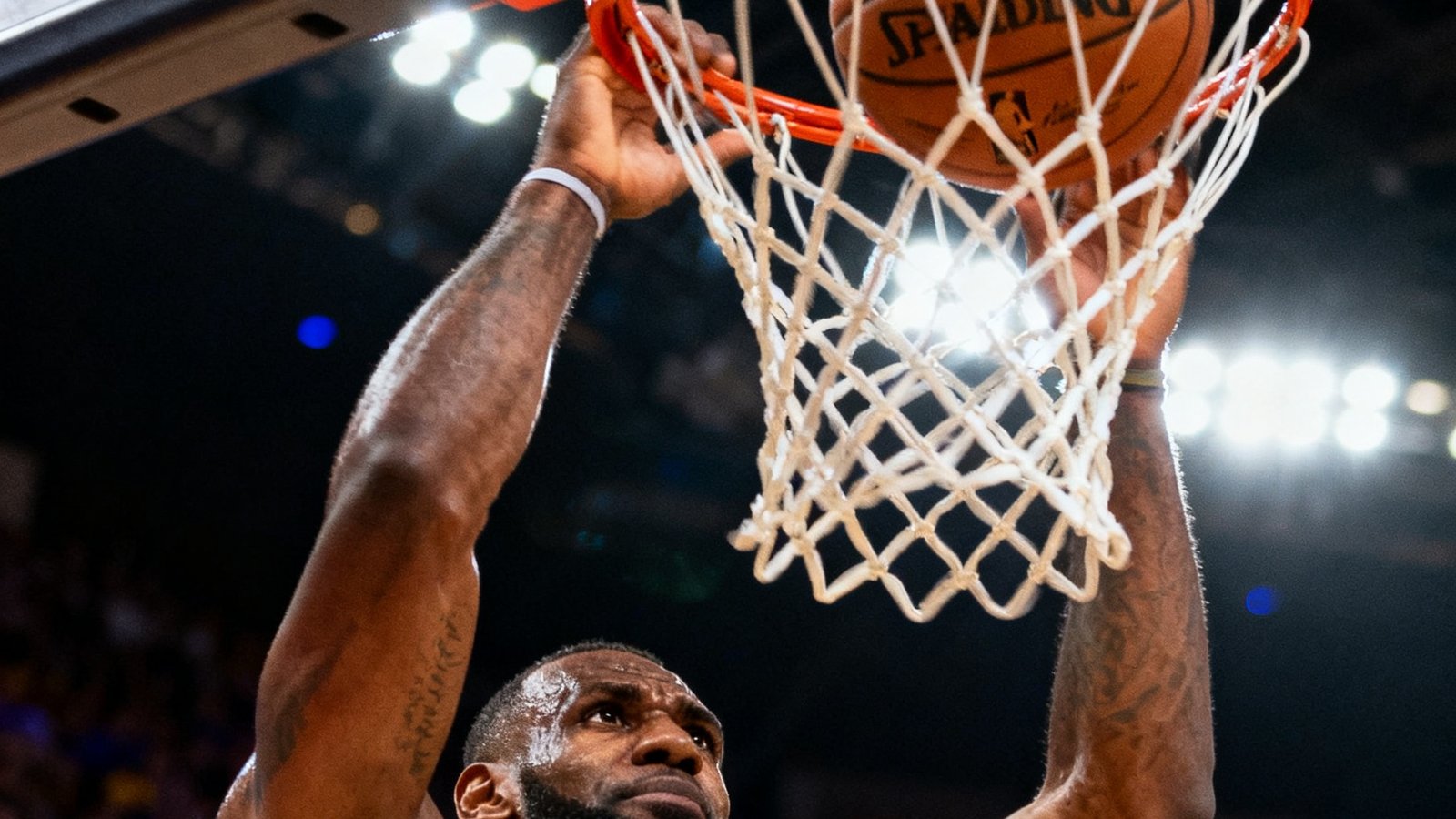 NBA比赛中勒布朗·詹姆斯精彩扣篮的回放画面，篮球即将入筐的瞬间特写